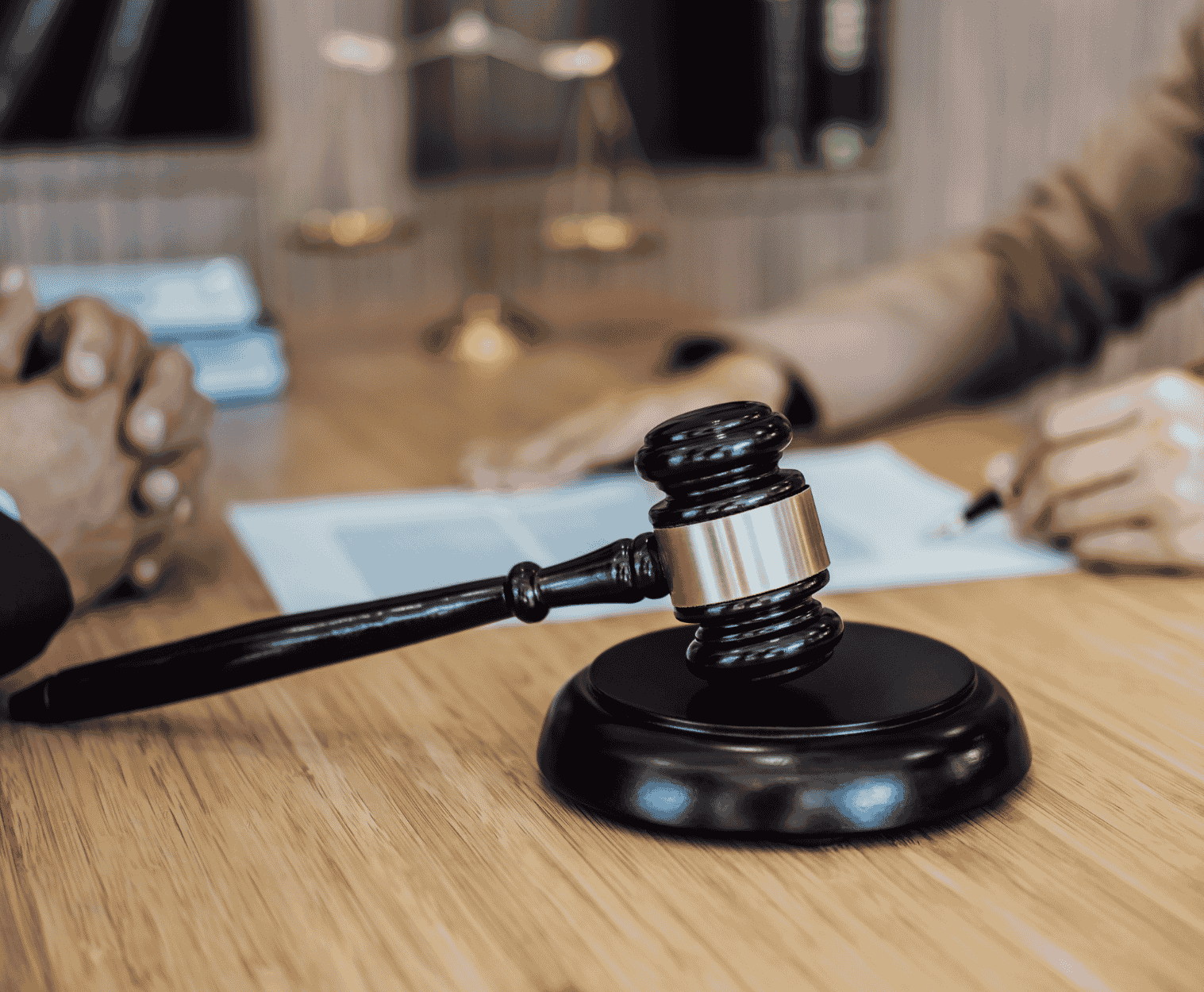 Martelo judicial sobre mesa durante atendimento jurídico, representando análise previdenciária e decisões relacionadas a benefícios do INSS.